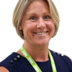 Connelee Usher smiling, in a navy blue dress with an Asda branded lanyard around her neck