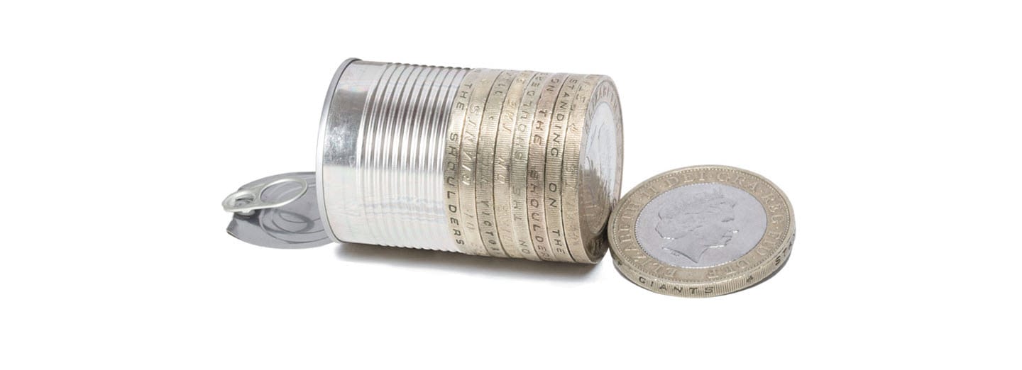 Half a tin can changing into british pound coins to depict waste to wealth