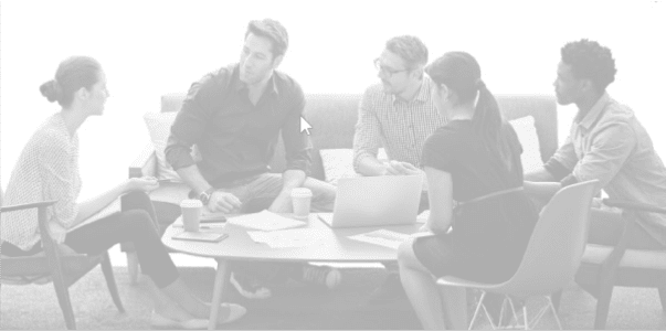 A group sit at a table in a diverse workplace