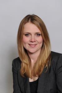 Catherine Dolton in a grey suit smiles at the camera