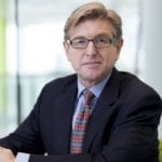 Keith Weed sits at a table with his hands clasped in front of him