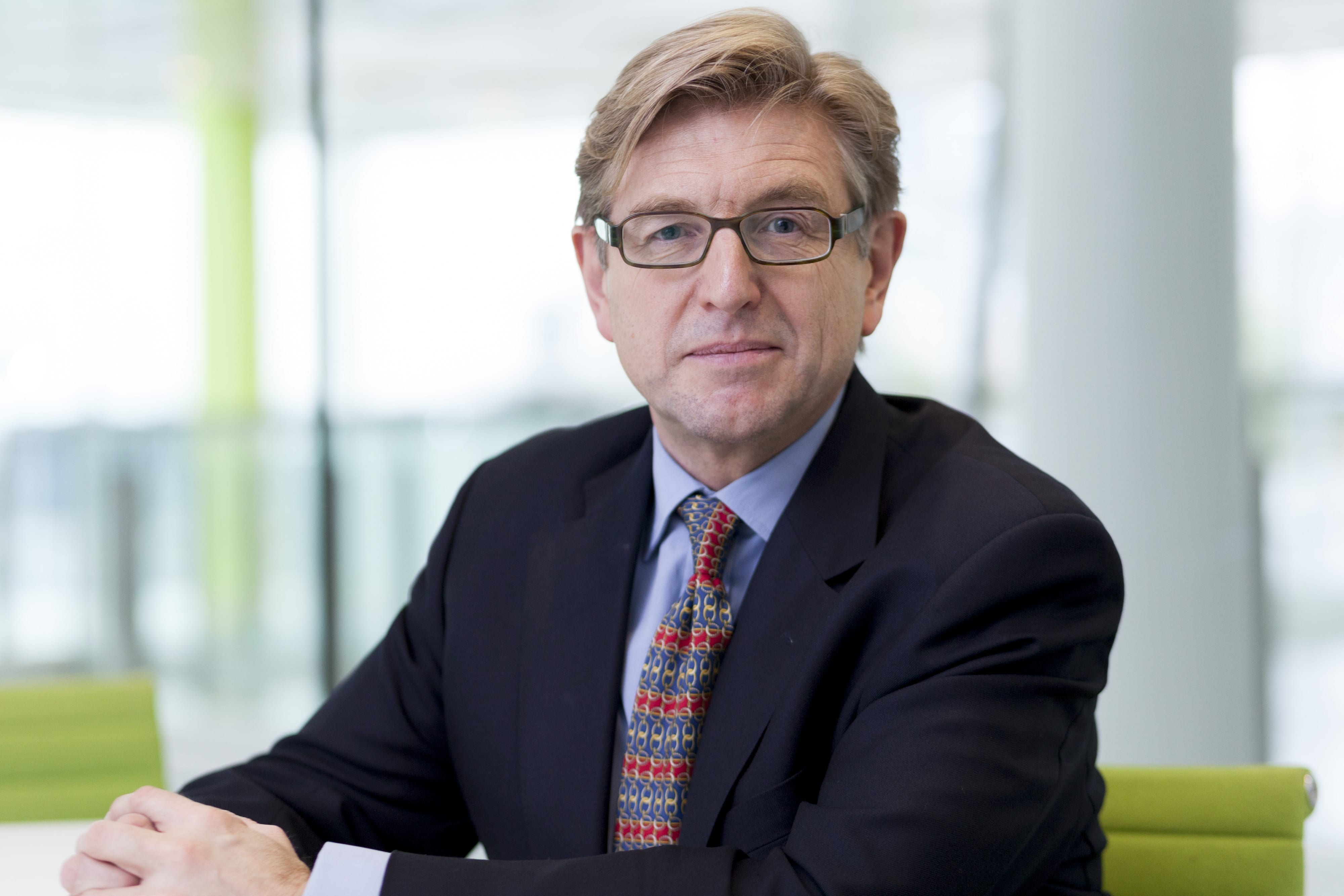 Keith Weed sits at a table with his hands clasped in front of him