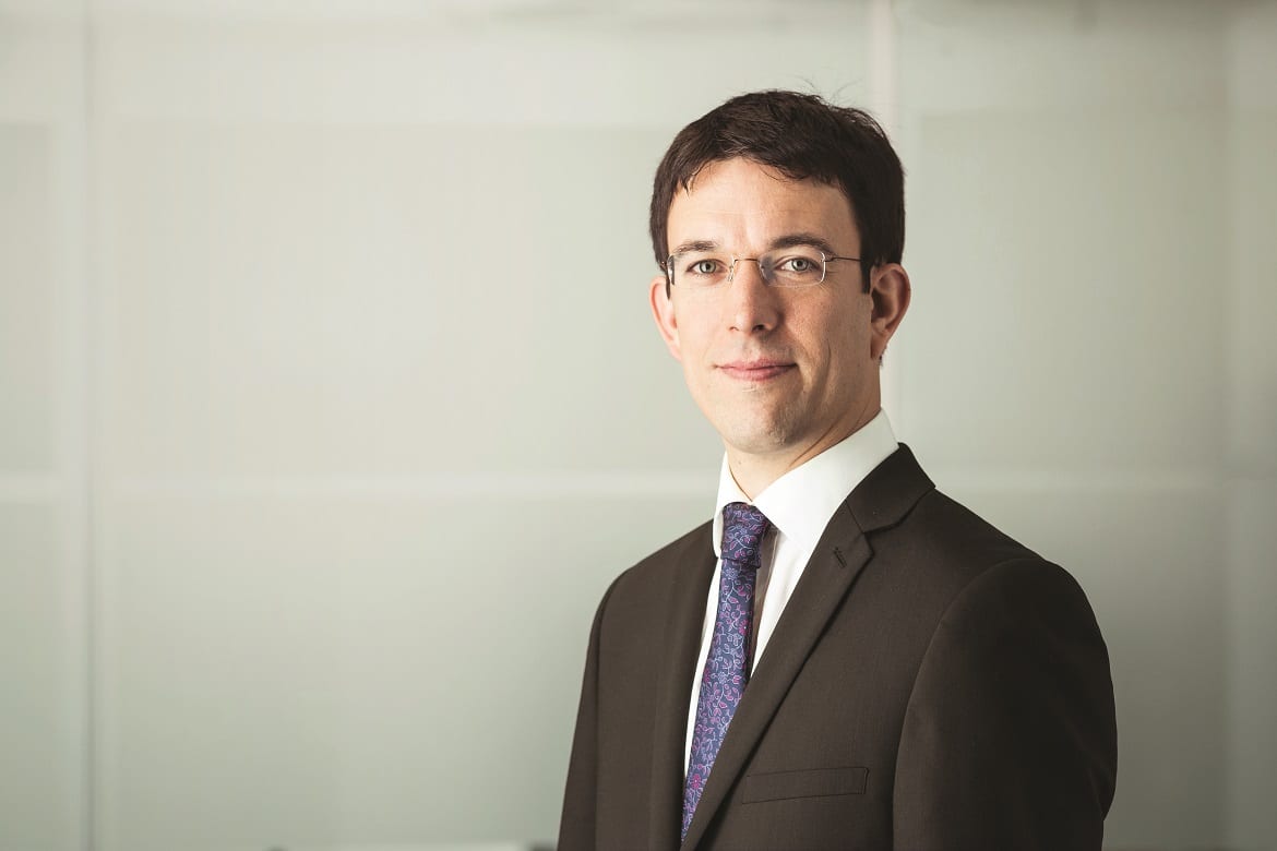 Richard Fearon wearing a suit, stands and looks at the camera