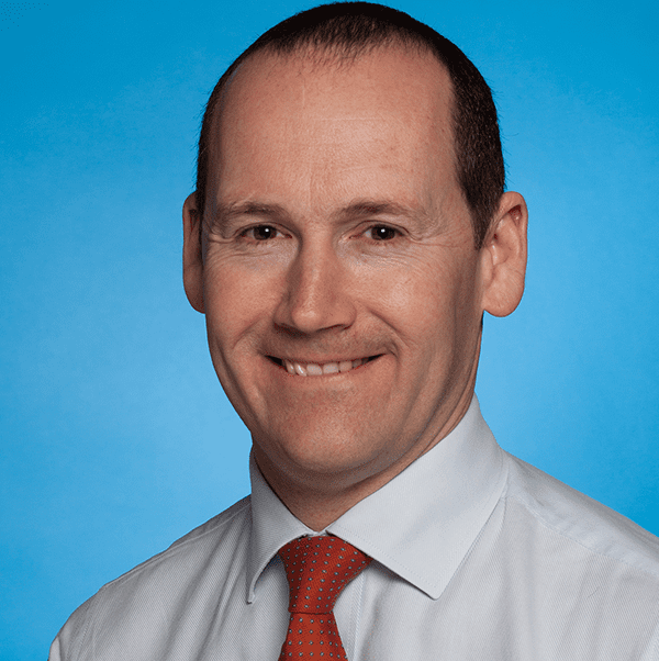 Richard Hutton, in shirt and tie, smiling