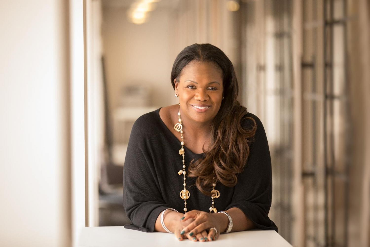 Vivian Hunt smiles and leans on a table